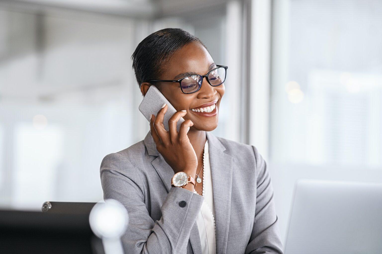 Successful african business woman talking on phone in office